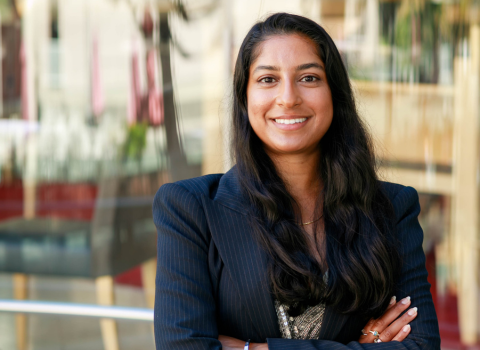 Alex Ramnarine, MSDS alum, headshot in a sharp blazer, arms crossed in a professional pose at civic center in California.