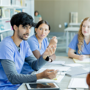 pre-medicine post-baccalaureate students gather around a table during a Proseminar Course.